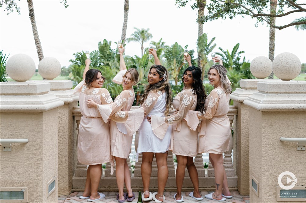 Bridesmaids champagne toast on the balcony of Naples, FL wedding venue. 